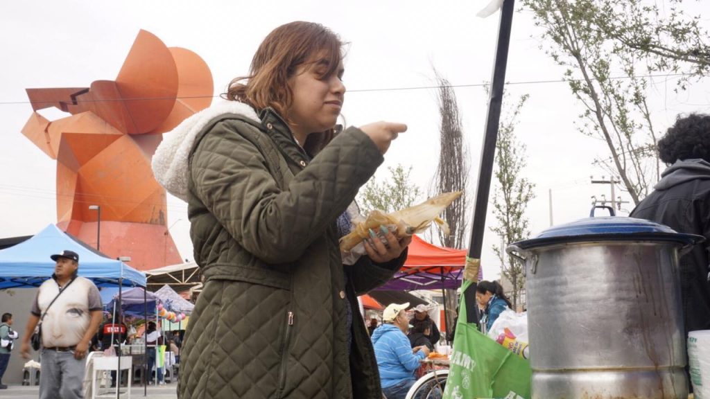 Una asistente a la Primera Feria del Tamal y el Atole Neza 2020 disfrutando del platillo mexicano